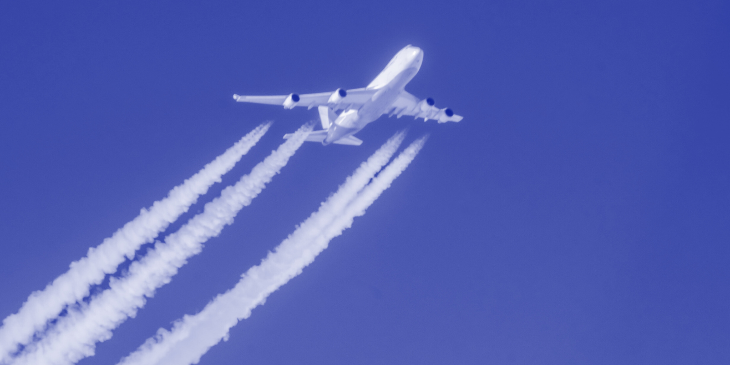 Avião e seu rastro de condensação, em contraste a imensidão do céu azul